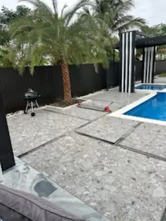 Patio terrazzo and pool deck with a palm beside the water